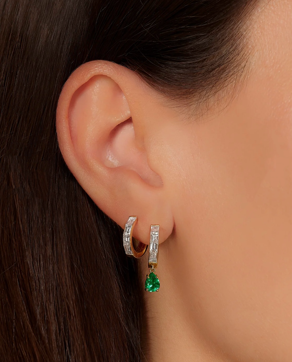 Baguette Diamond And Emerald Huggies on left ear